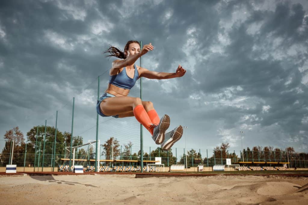 Female athlete performing a long jump during a competition