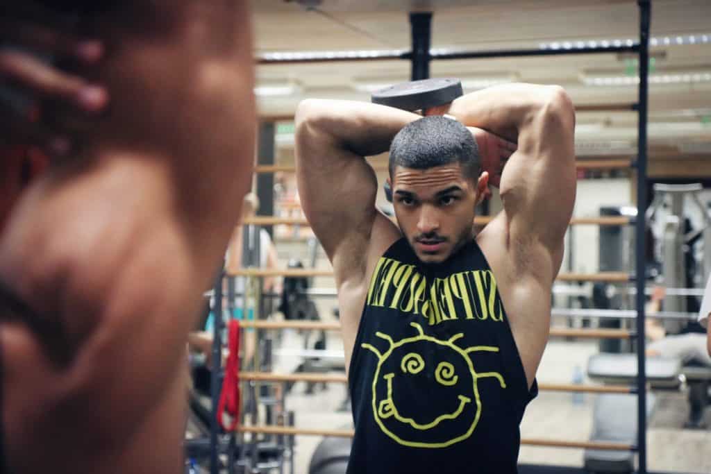 Muscular guy lifting weights in the gym