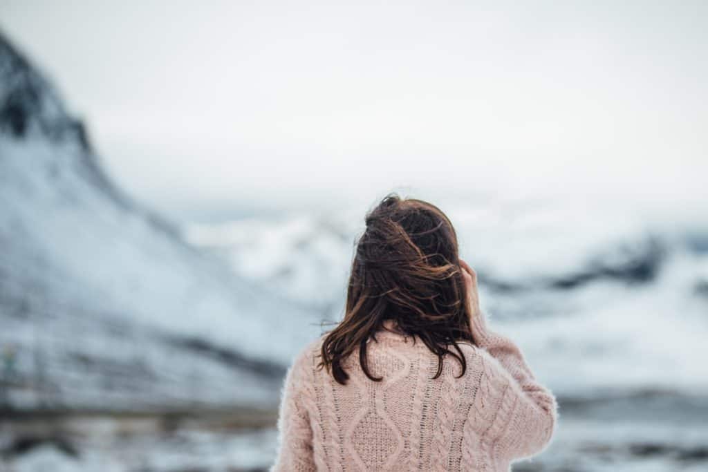 Woman in pink sweater overlooking mountains