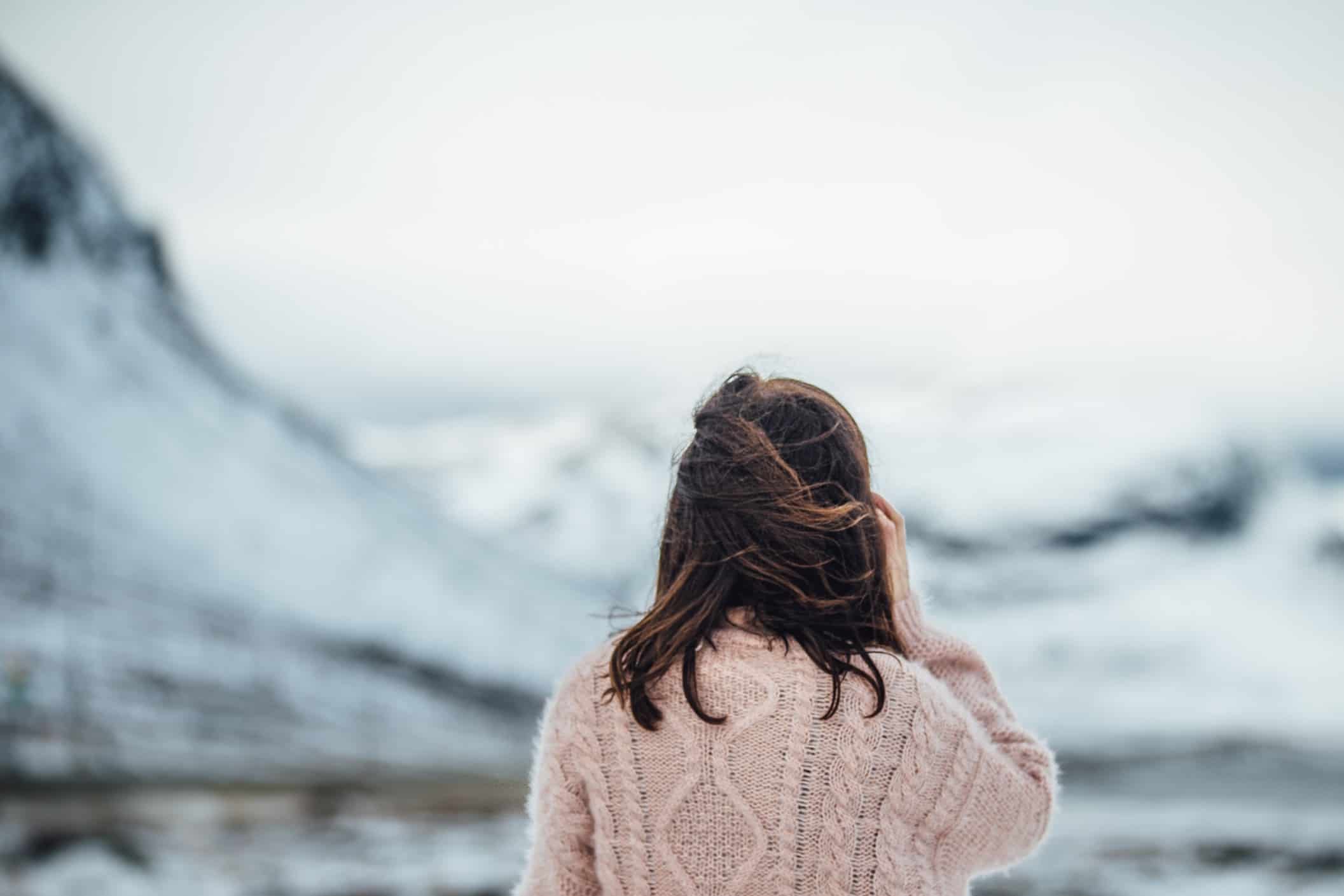 Woman in pink sweater overlooking mountains