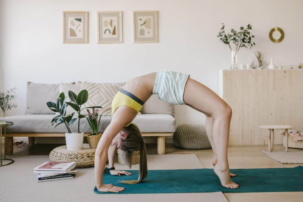 young woman doing yoga in her light living room